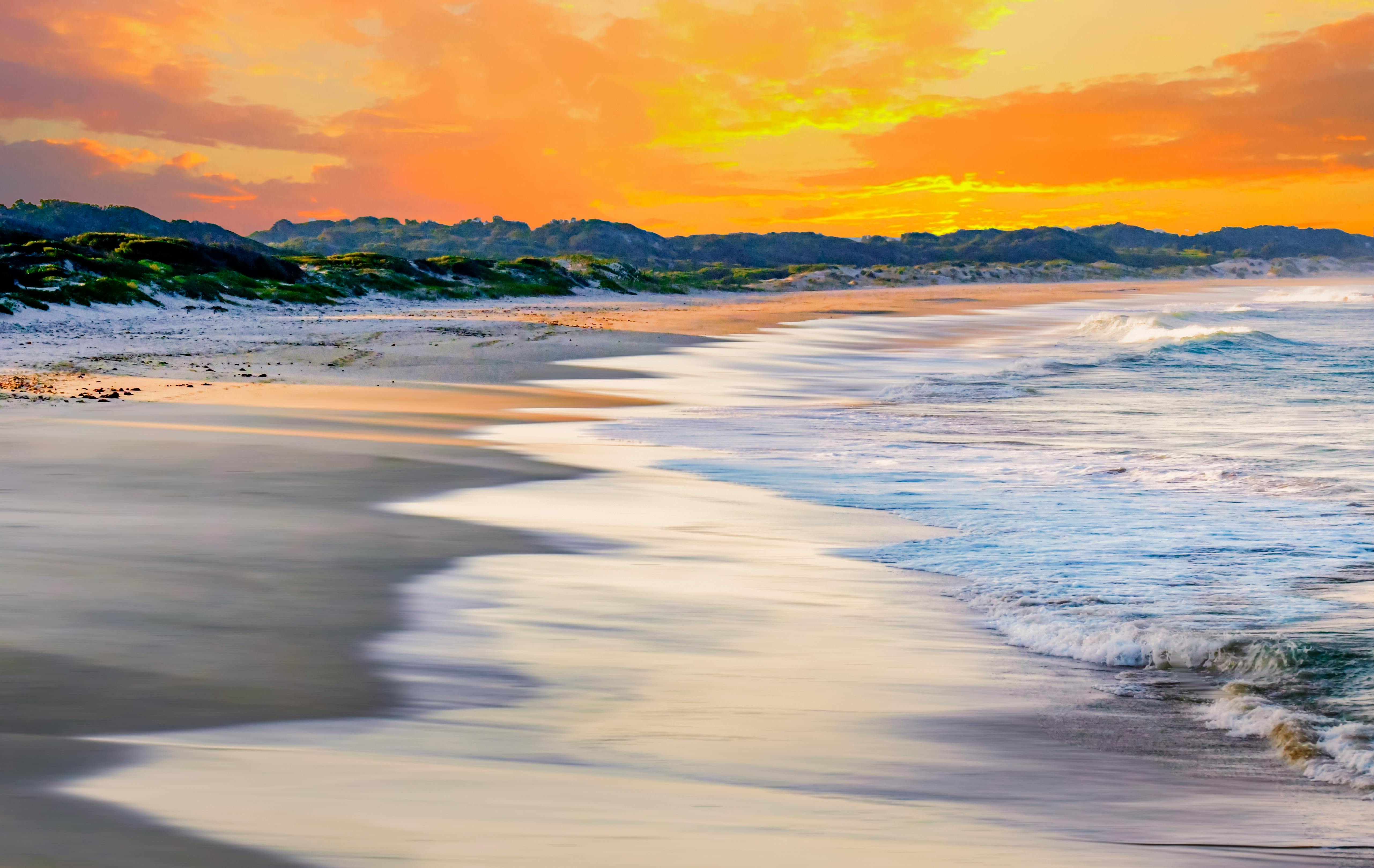 南非海岸边，海浪平静，日落充满活力