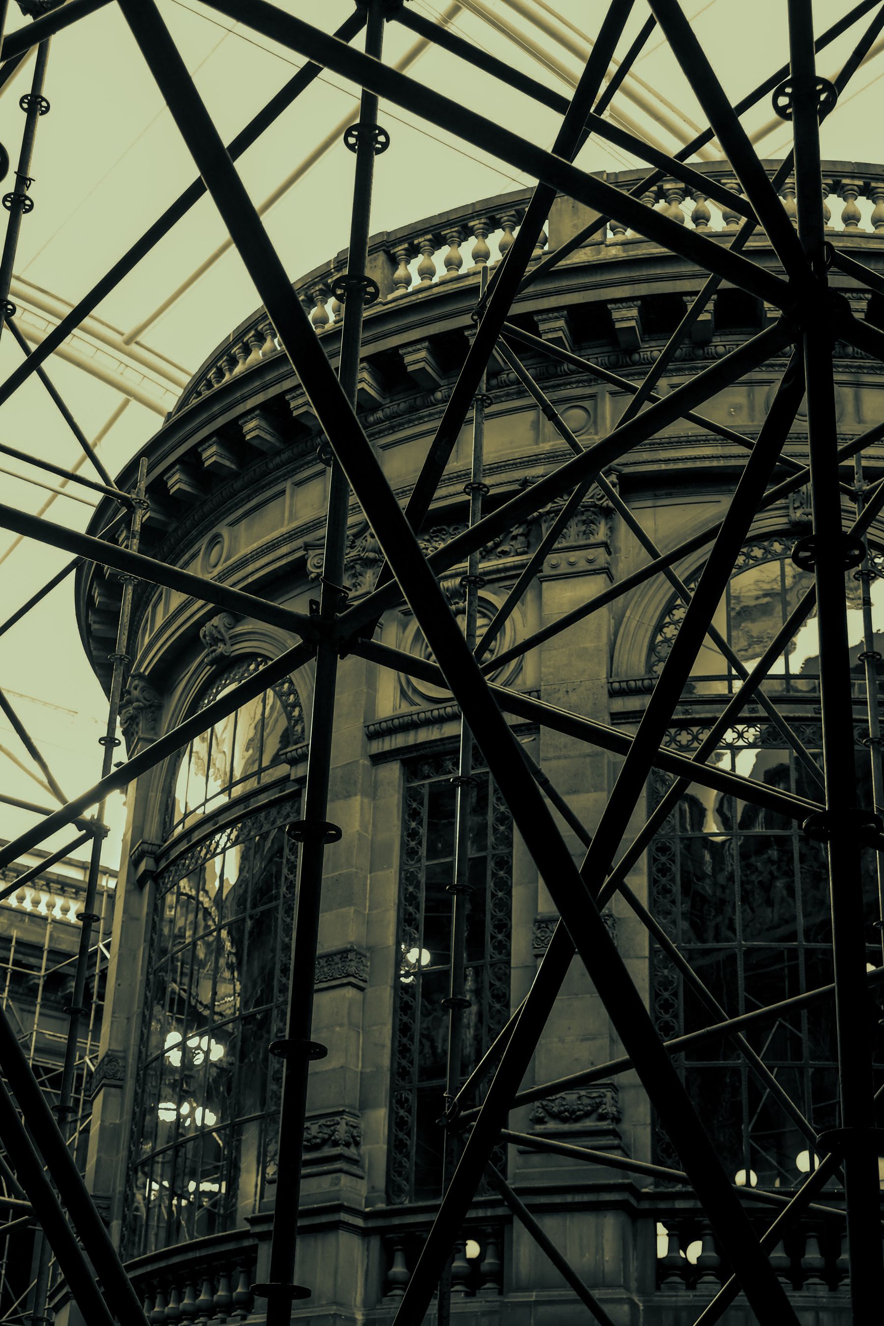 Architectural structure behind industrial framework under a clear sky.
