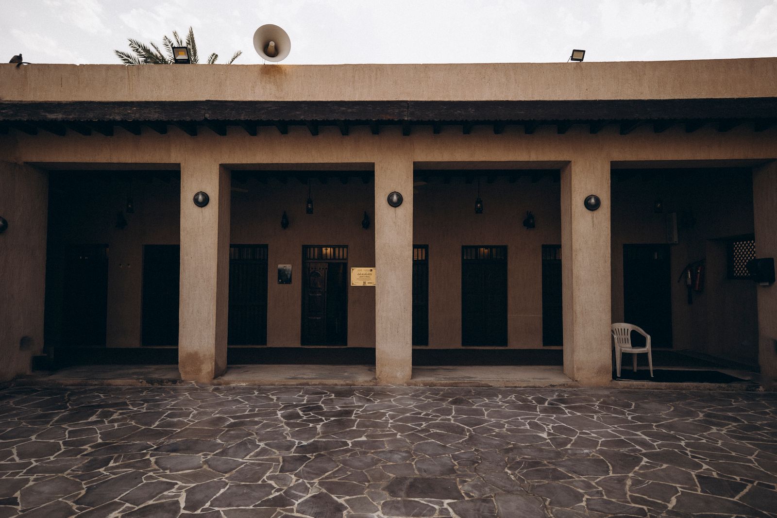 Stone-paved courtyard and shaded doorways of a restored house in the Al Shindagha historic district