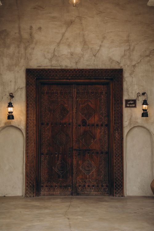 Free Elegant carved wooden door with vintage lanterns in Old Dubai, UAE showcasing historical architecture. Stock Photo