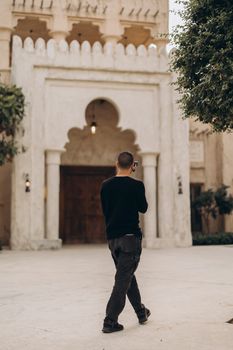 Man photographing historical architecture in Dubai's Shindagha district.