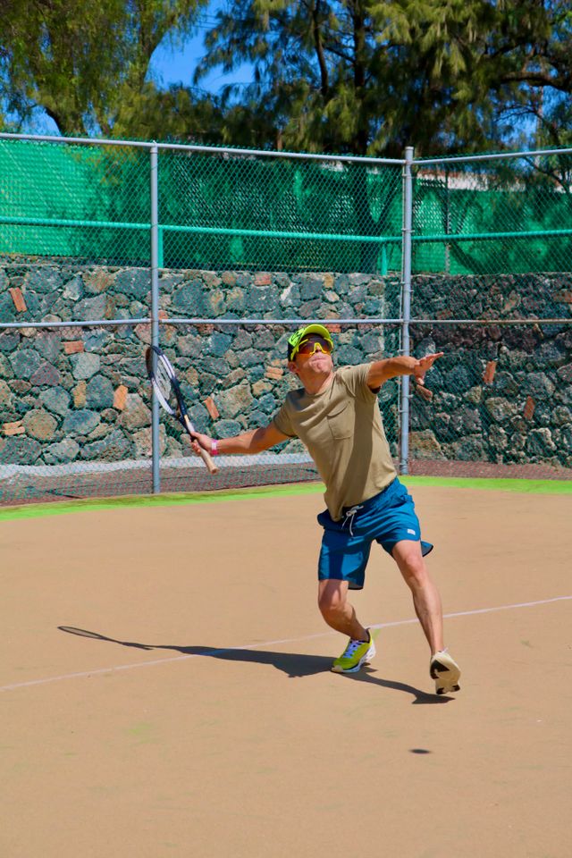 Tennis player serving on an outdoor court