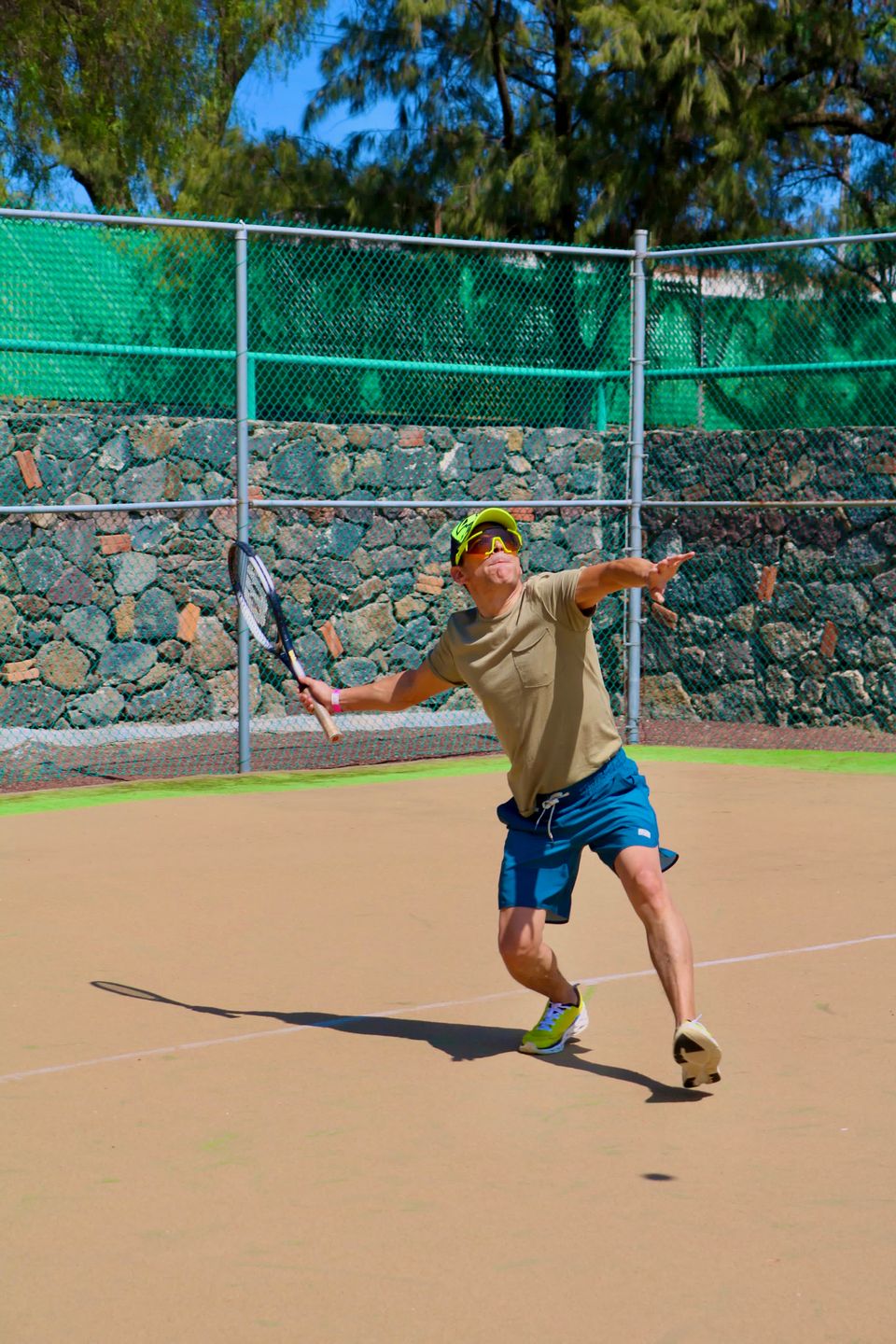 Tennis player serving on an outdoor court
