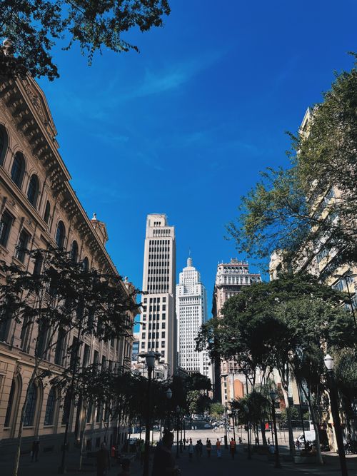 Free Vibrant cityscape featuring historic and modern skyscrapers under a clear blue sky. Stock Photo