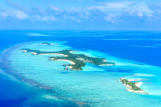 Stunning aerial shot of turquoise waters and tropical islands in Maldives.