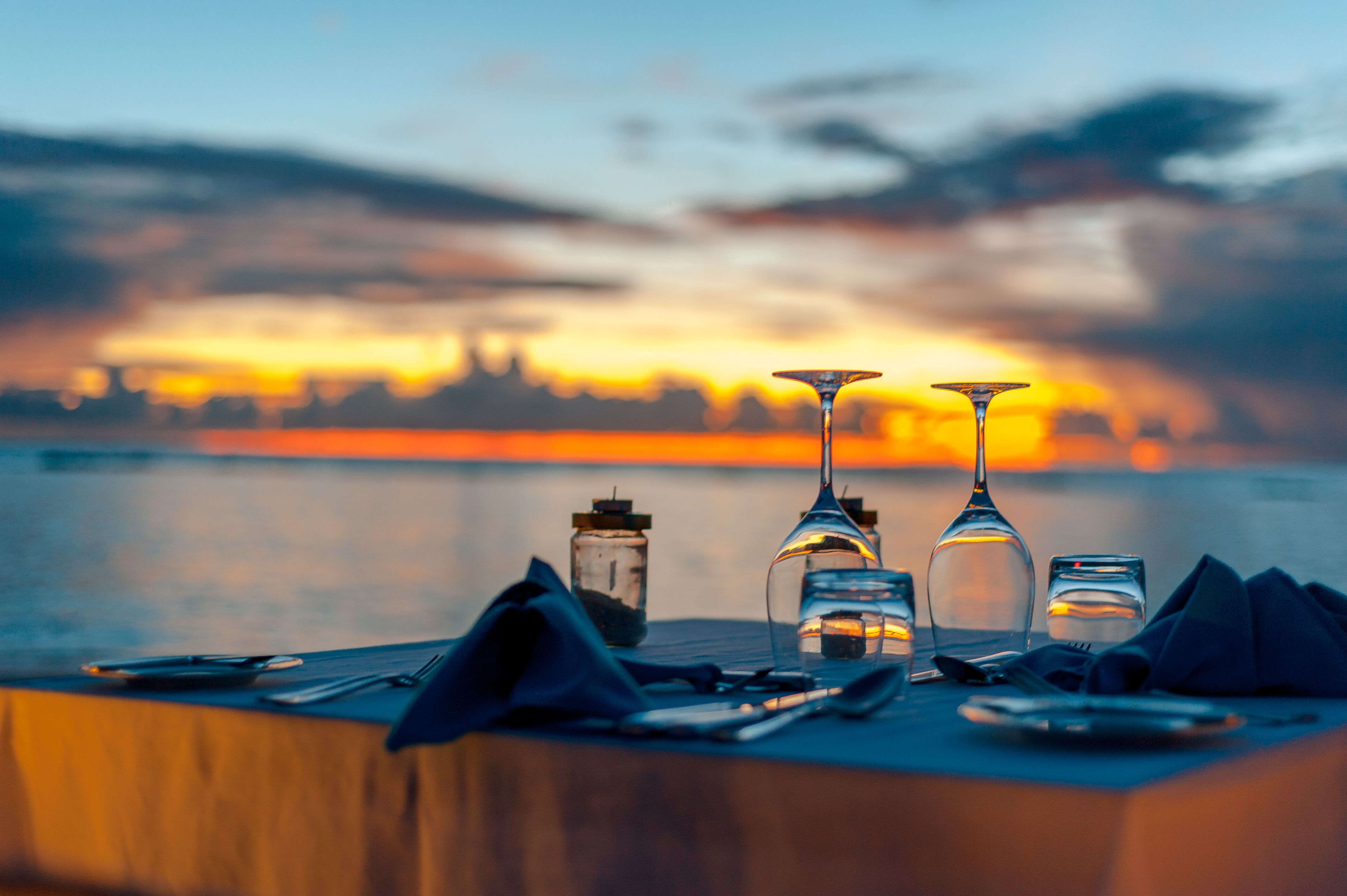 Elegant oceanfront dinner setup at sunset at a Hawaii luxury resort