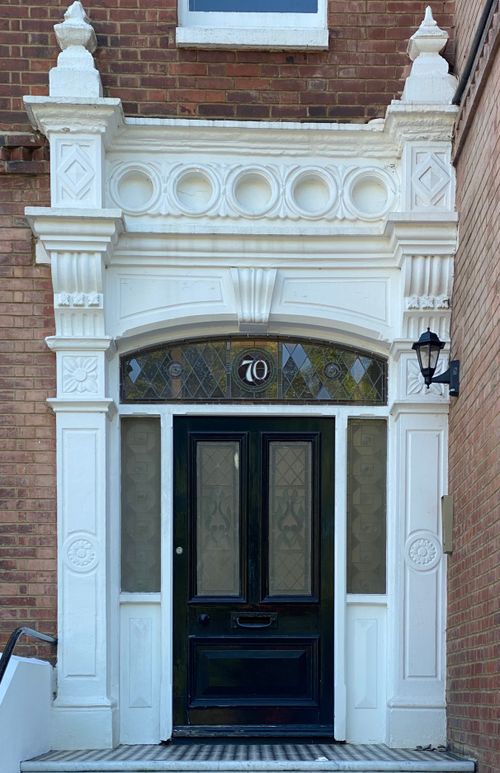 Free Intricately designed entrance with white detailed trimming in a classic brickwork building. Stock Photo