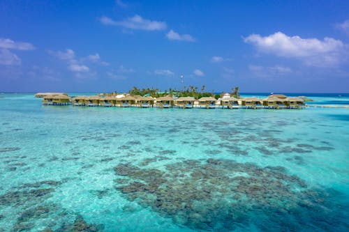 Free Aerial view of picturesque overwater bungalows in Maldives' turquoise waters. Stock Photo