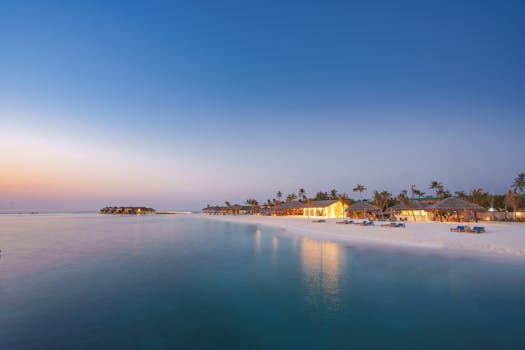 Beautiful island resort in the Maldives with white sand beaches and serene turquoise waters at sunset.