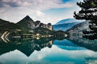 清澈的湖泊倒映着锯齿状的山峰和郁郁葱葱的绿意，构成了一幅令人惊叹的自然景观