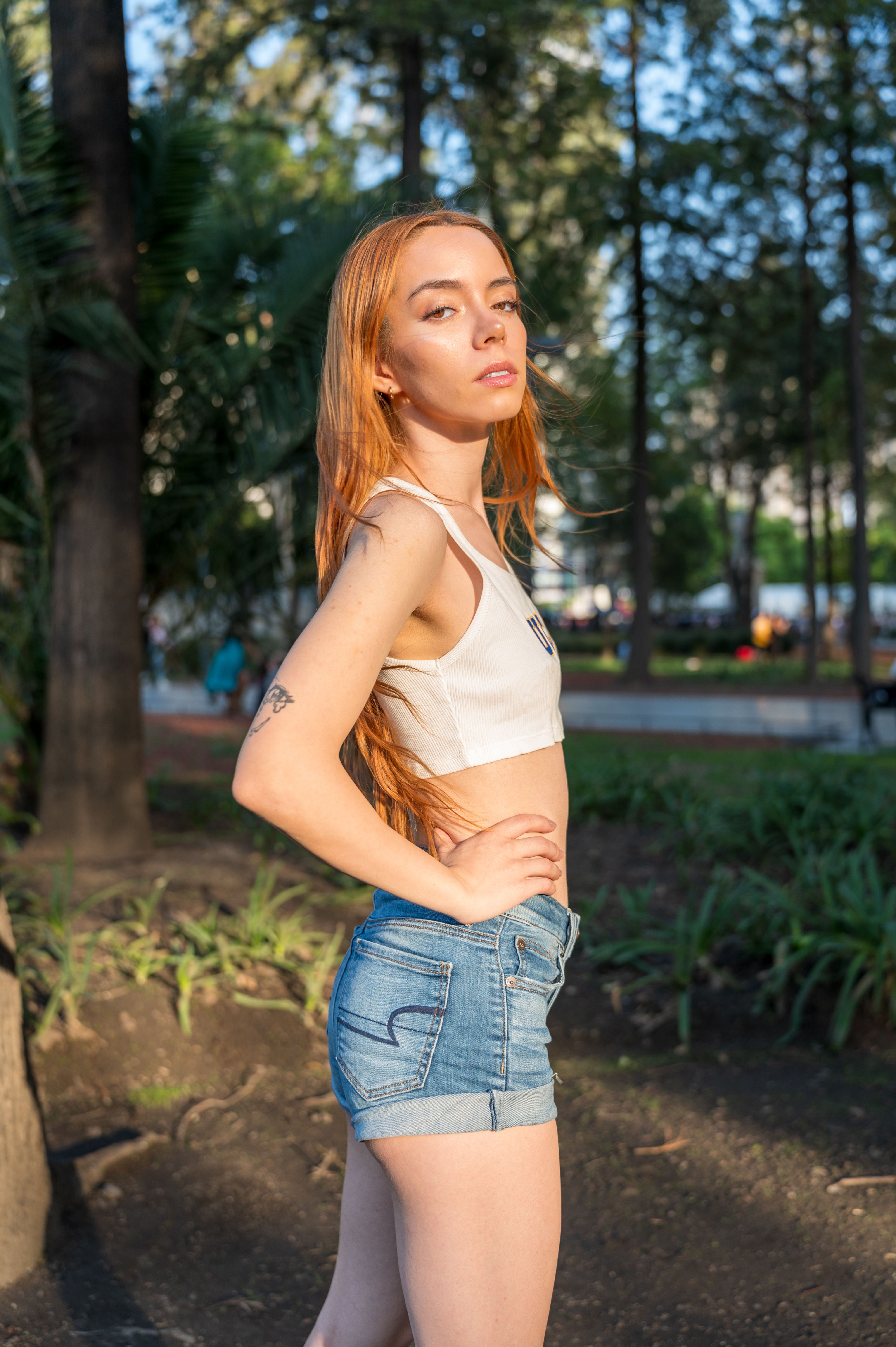 Stylish Redhead Woman in Urban Park Setting · Free Stock Photo