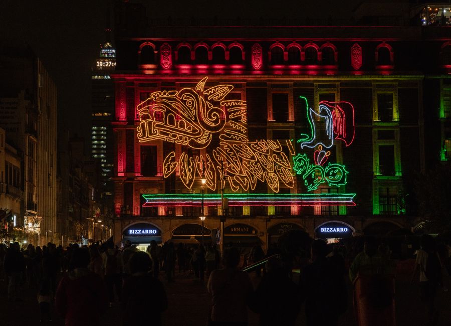 A vibrant neon display celebrating Mexican Independence Day at night in Mexico City.