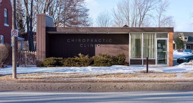 Exterior view of a modern chiropractic clinic in a snowy suburban neighborhood.