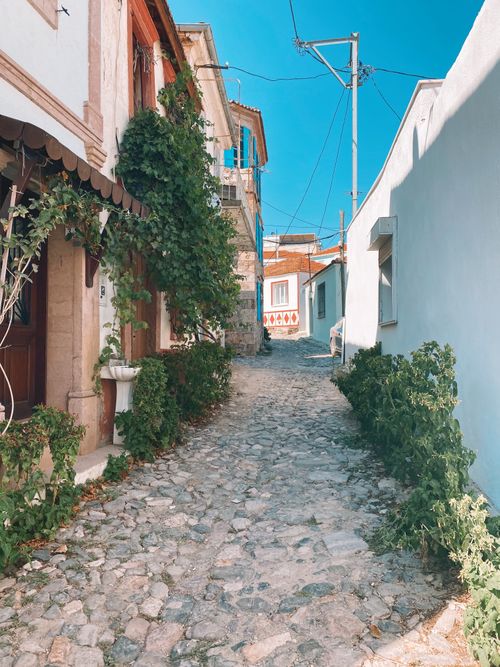 Free Explore a sunlit, cobblestone street in a picturesque Turkish village, capturing Mediterranean charm. Stock Photo
