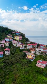 Vibrant hillside community with colorful houses by the sea under a bright sky.