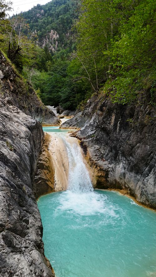 Free Picturesque waterfall cascading in a tranquil mountain ravine. Stock Photo