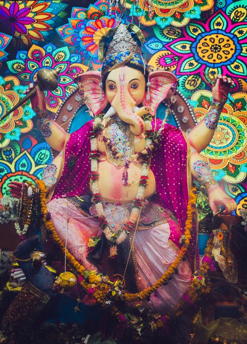 Free Elegant Ganesha idol adorned in traditional attire, surrounded by vivid floral patterns in Purnia, India. Stock Photo