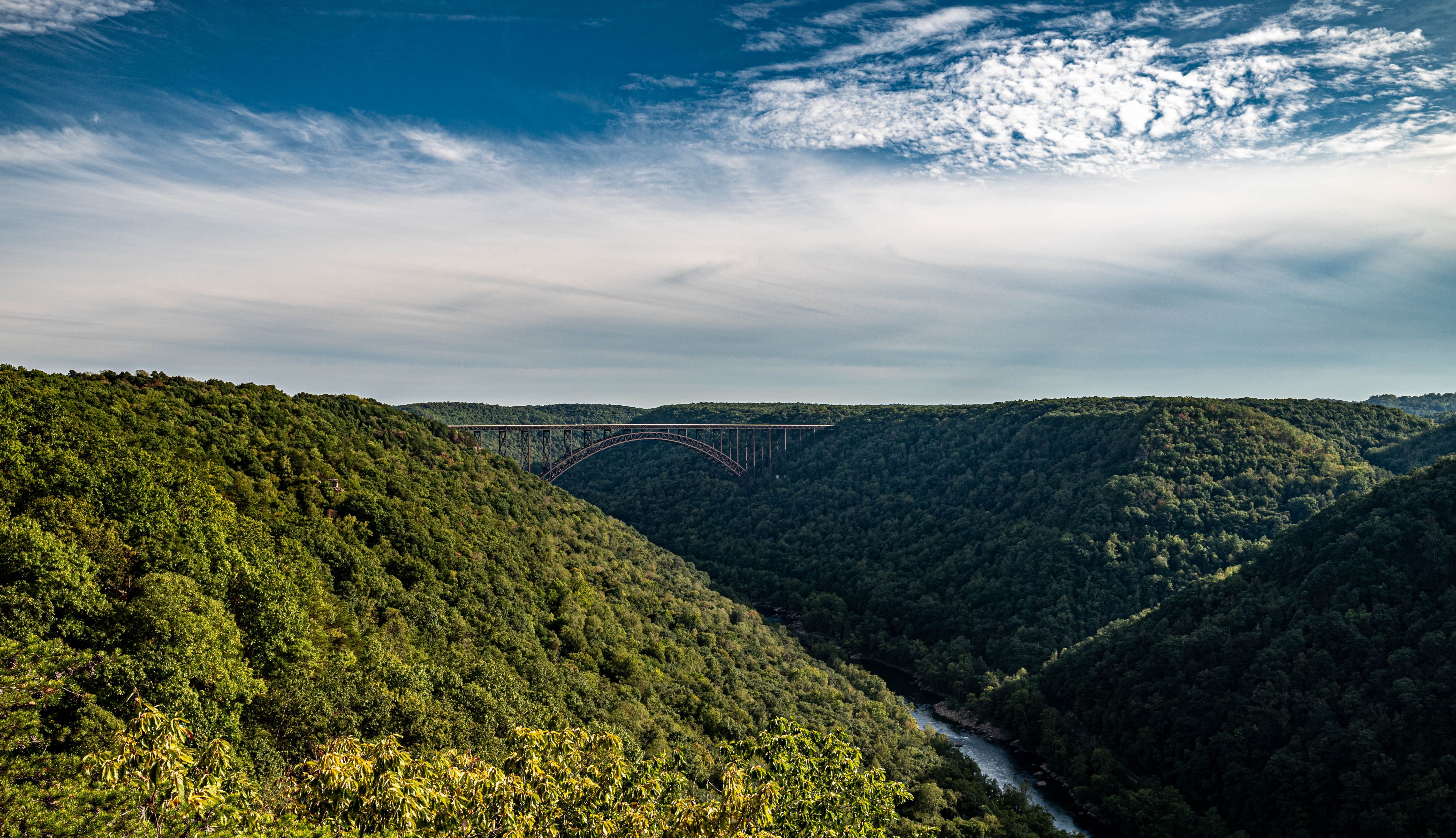 Breathtaking view of lush green mountains with a bridge in the distance