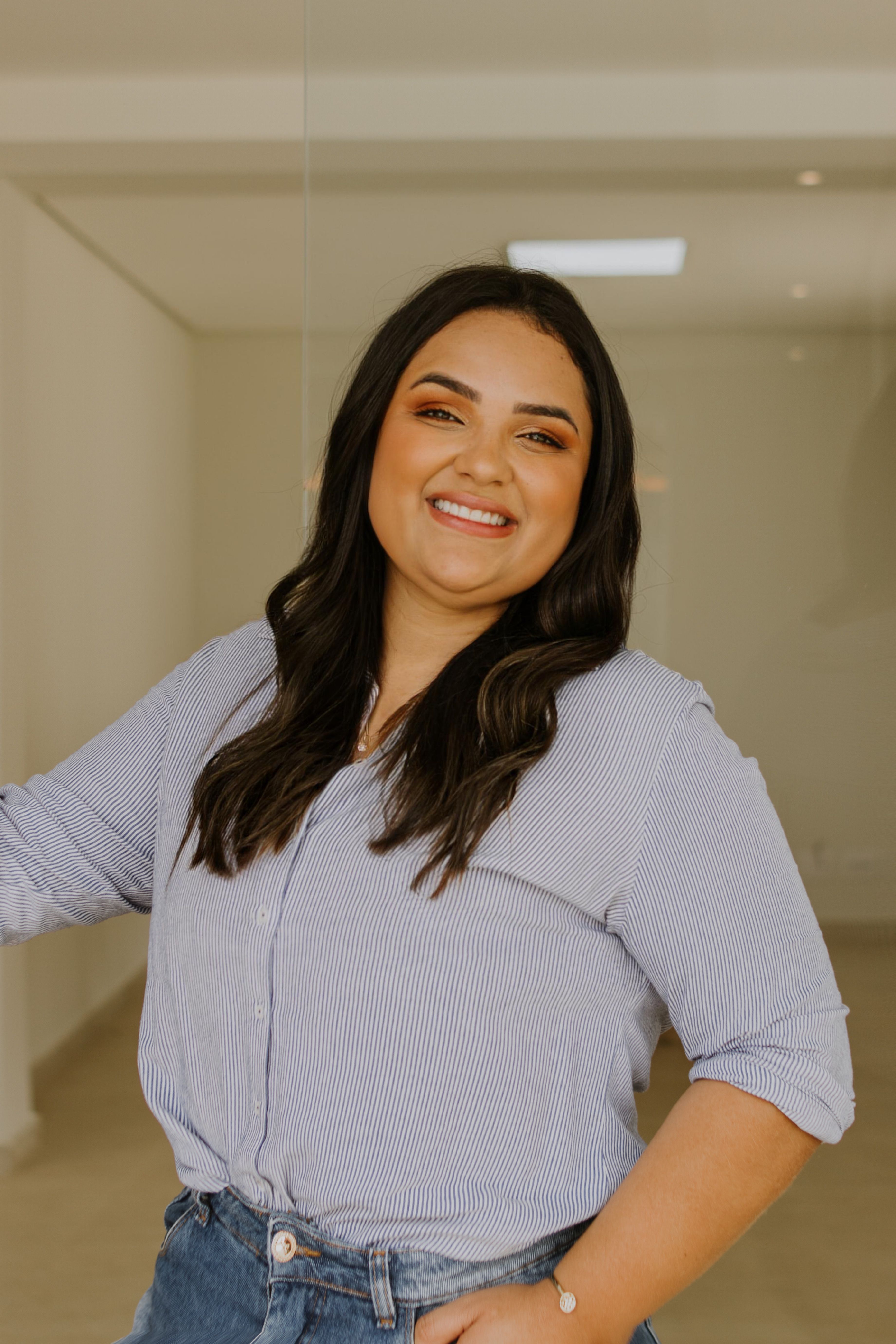 Portrait of a smiling woman indoors, radiating confidence and positivity in a casual setting.