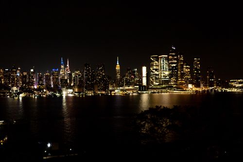 Free Captured from the waterfront, New York City skyline shines brilliantly against the night sky. Stock Photo