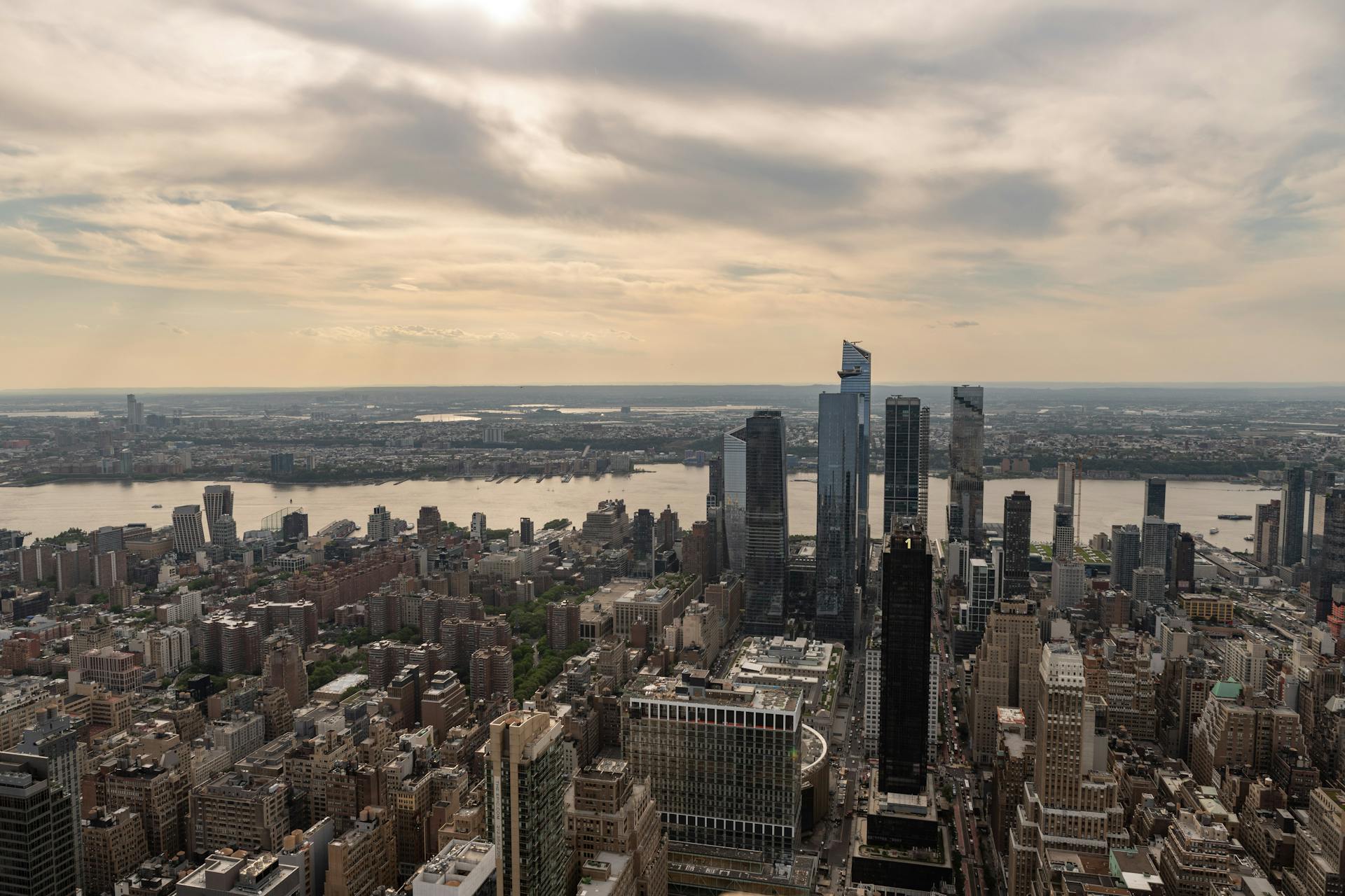 A breathtaking aerial view of New York City with skyscrapers and the Hudson River at dusk.