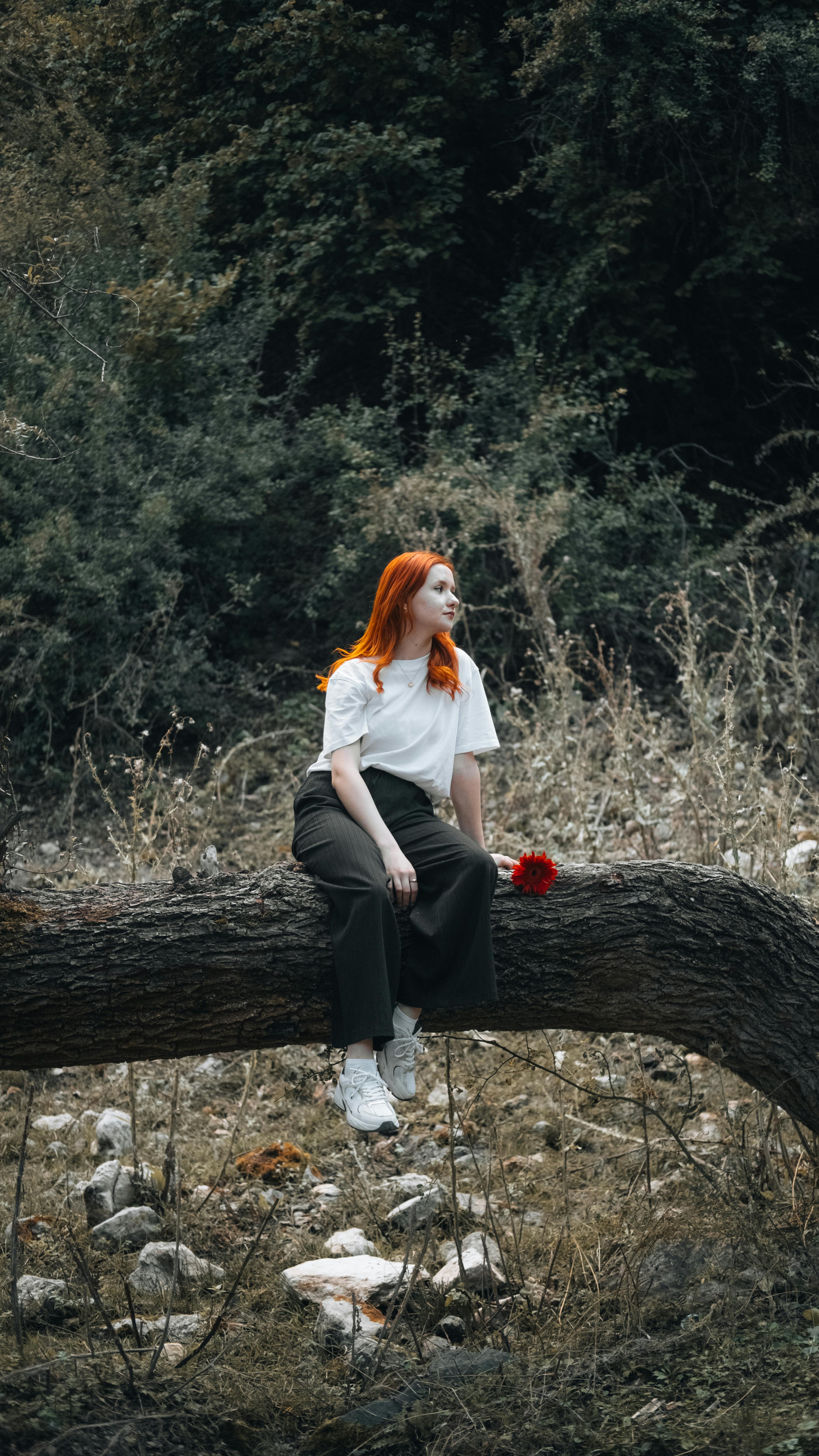 redhead woman with flower in forest setting