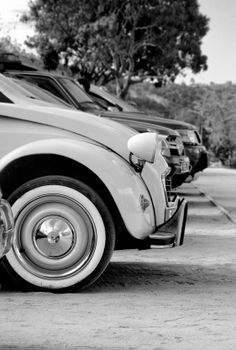 Classic cars parked outdoors in a vintage, monochrome style. Captures retro automotive elegance.