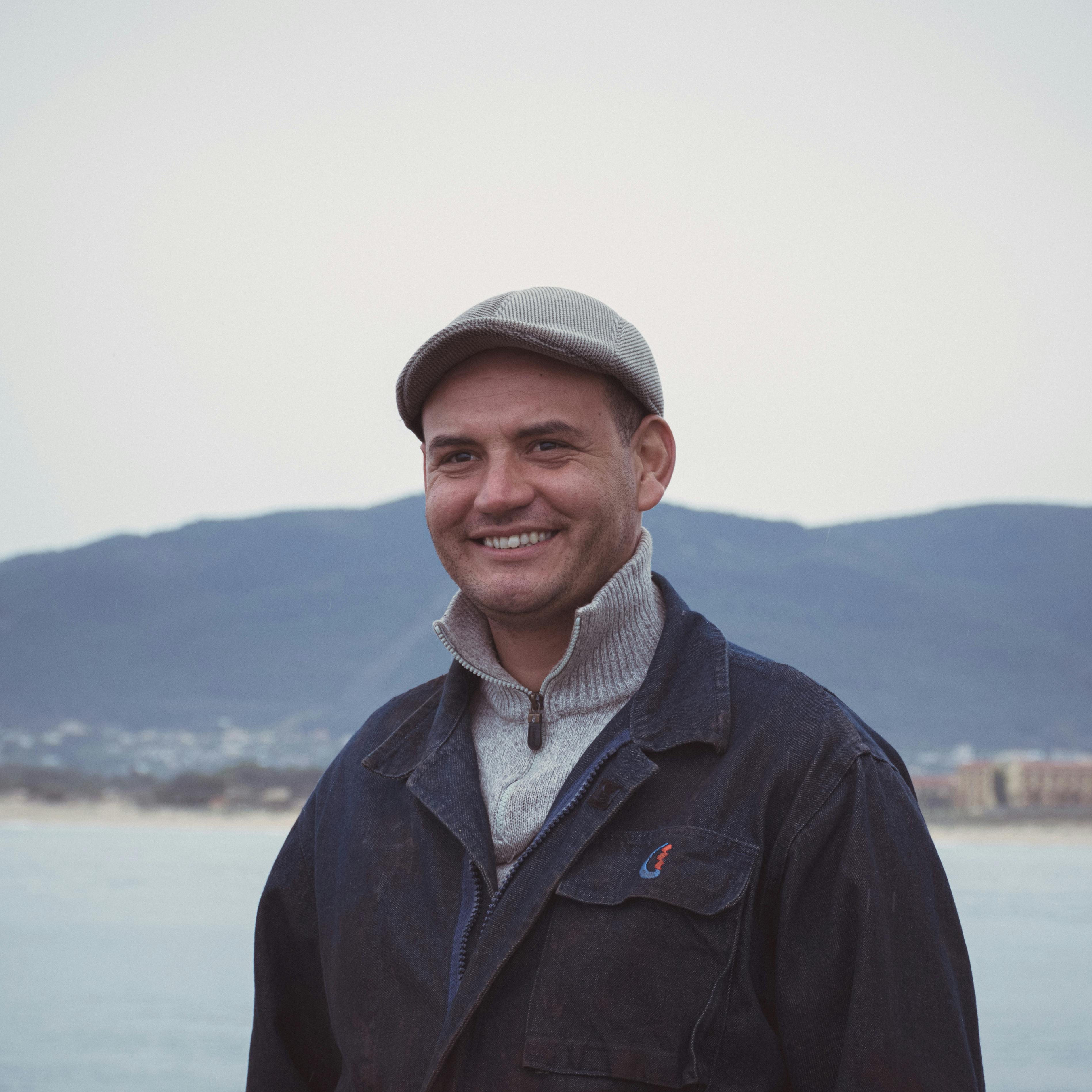 A joyful man wearing a cap by the Mediterranean Sea in Tabarka, Tunisia.