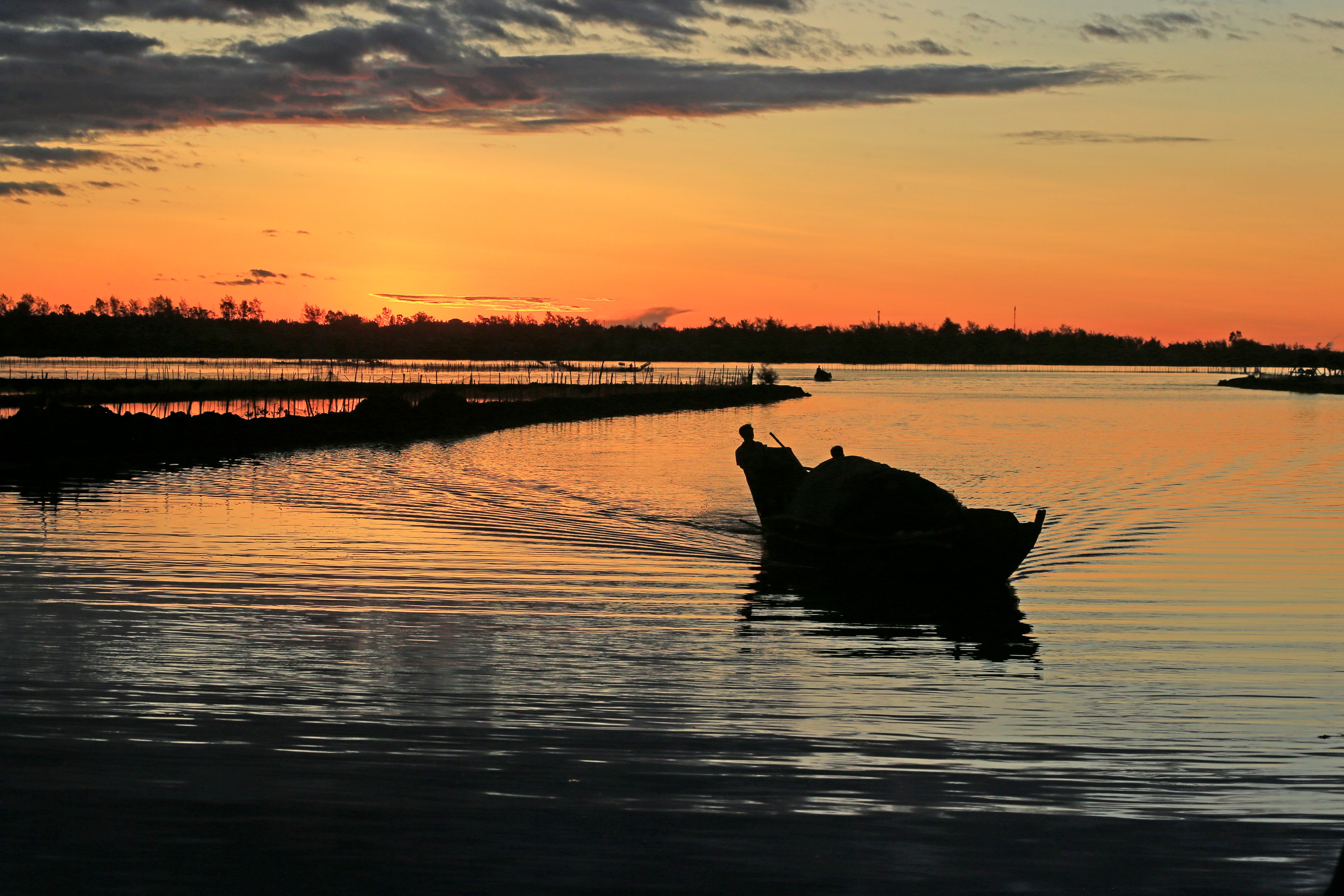 Silhouette of Boat on Tranquil Sunset Lake · Free Stock Photo