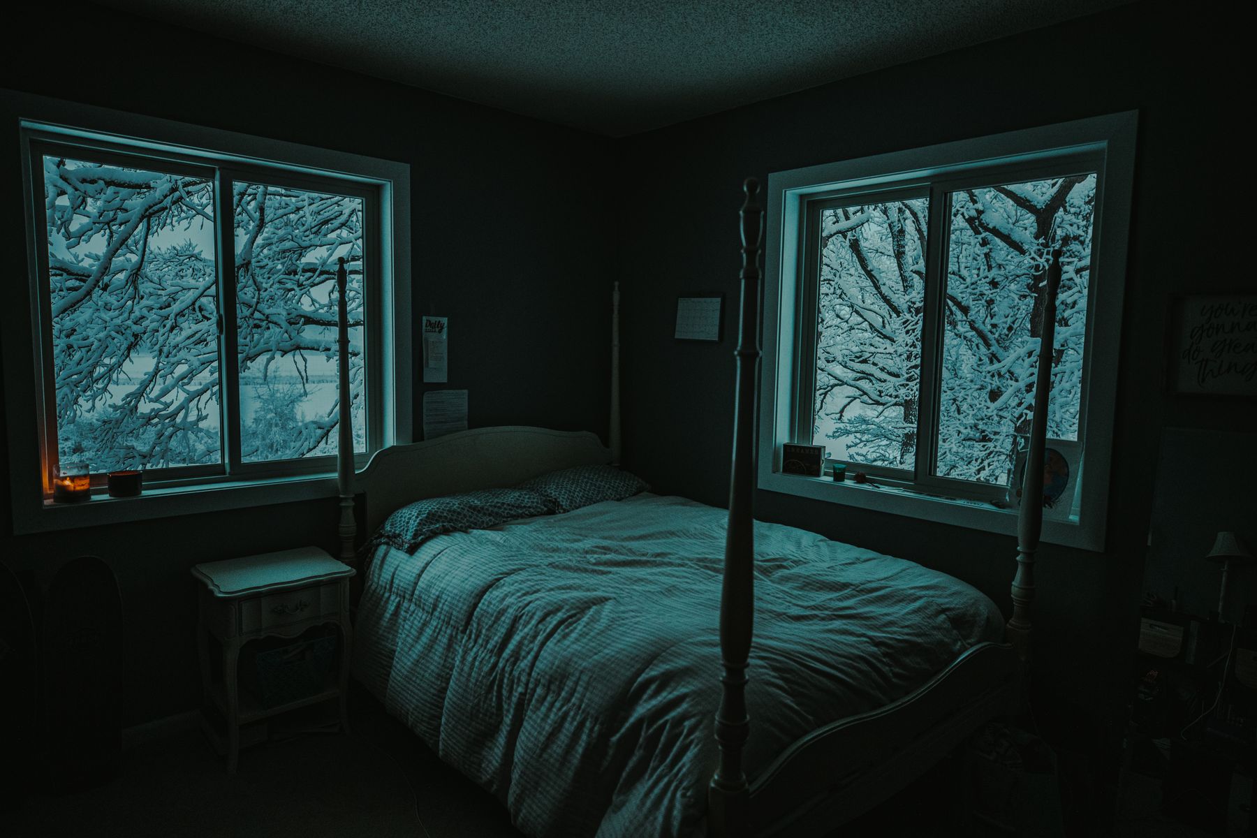 Bedroom interior looking out toward snowy trees through a window