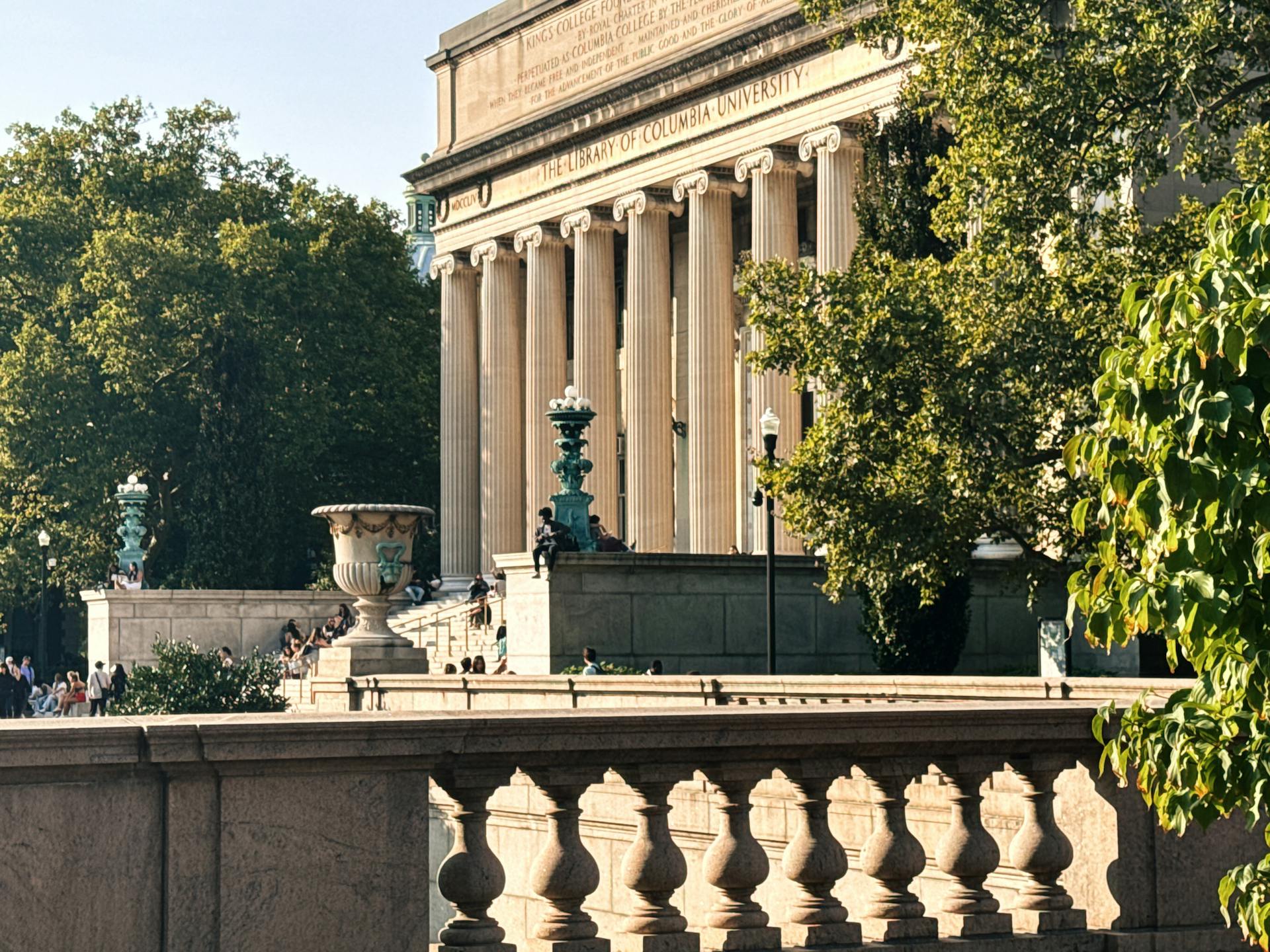 Sunny day at Columbia University Library, blending classic architecture with vibrant greenery.