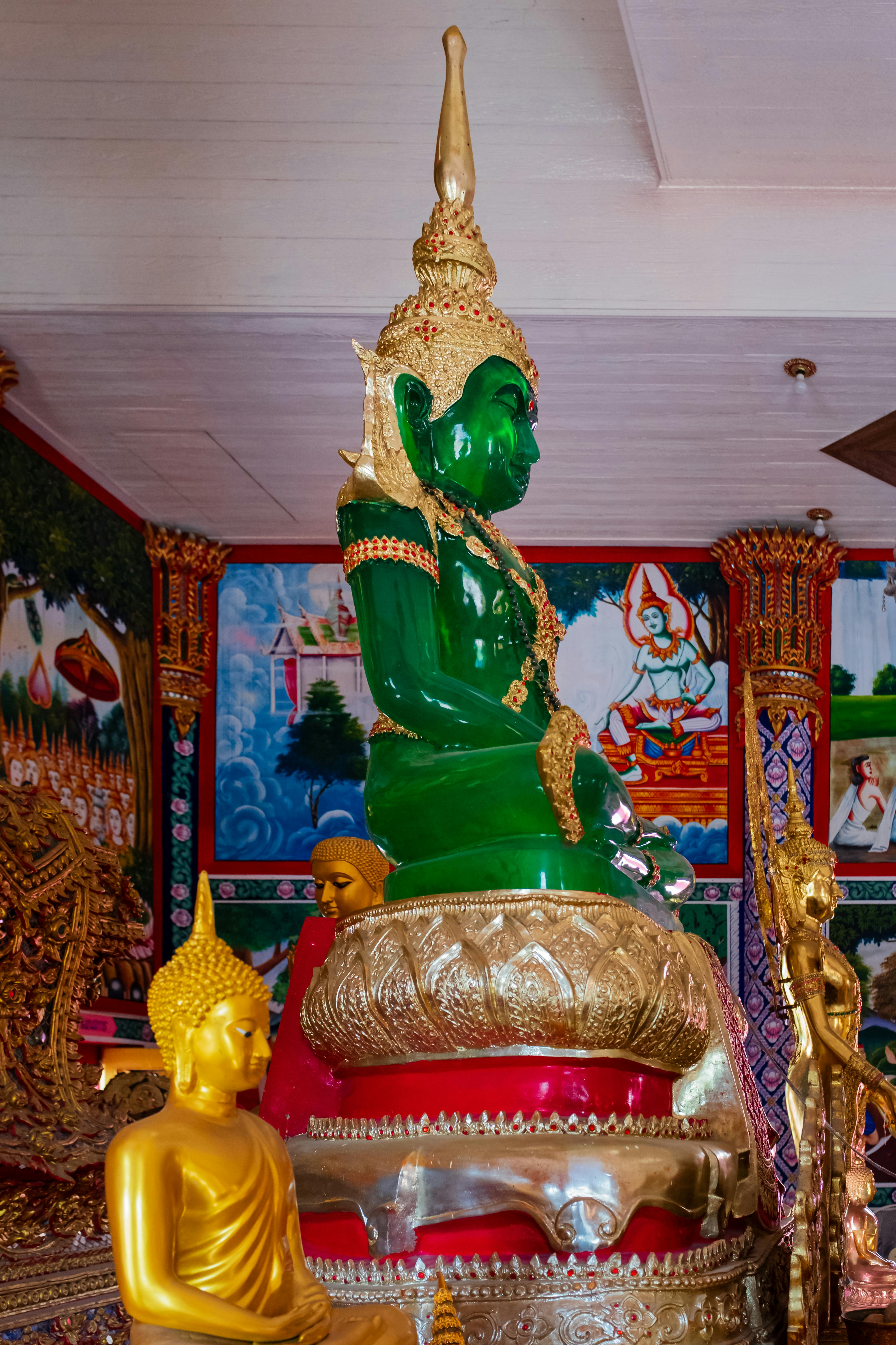 Vibrant emerald Buddha statue in a richly decorated Bangkok temple, highlighting Thai culture.