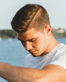 明亮的天空下，一位年轻人在水边的肖像