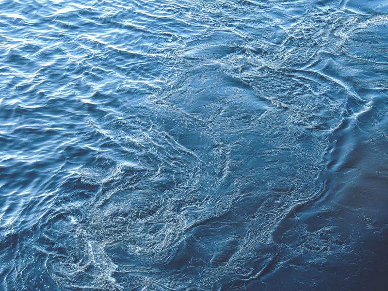 Close-up of clear blue water with ripples, showcasing texture and motion.