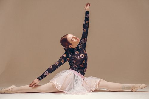 Free A ballerina poses gracefully, showcasing her flexibility and artistic expression in a studio setting. Stock Photo