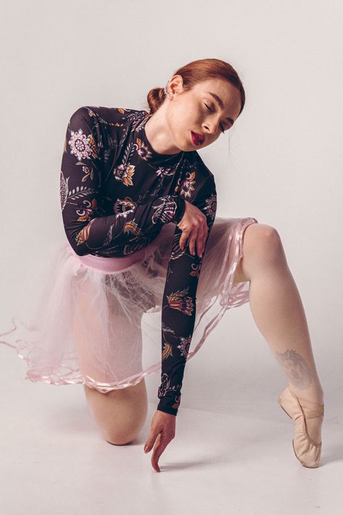 Free A young ballerina gracefully poses in floral attire, capturing the essence of dance and elegance. Stock Photo