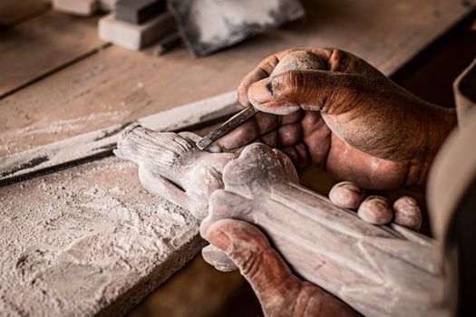Close-up of an artisan's hands carving stone in Cusco, showcasing traditional craftsmanship.