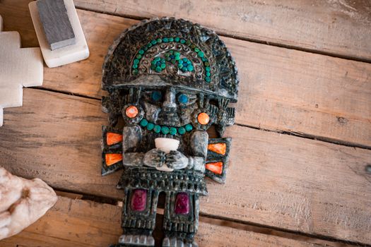A detailed Incan-style artifact showcasing vibrant colors and craftsmanship on wooden background.