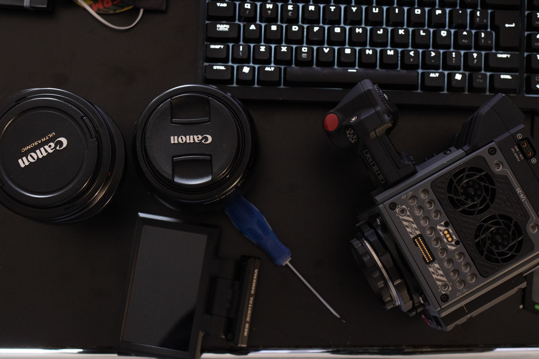 CapCut 新手到進階:剪輯流程與快捷鍵全攻略 Close-up of camera gear and keyboard on a work desk for media production.