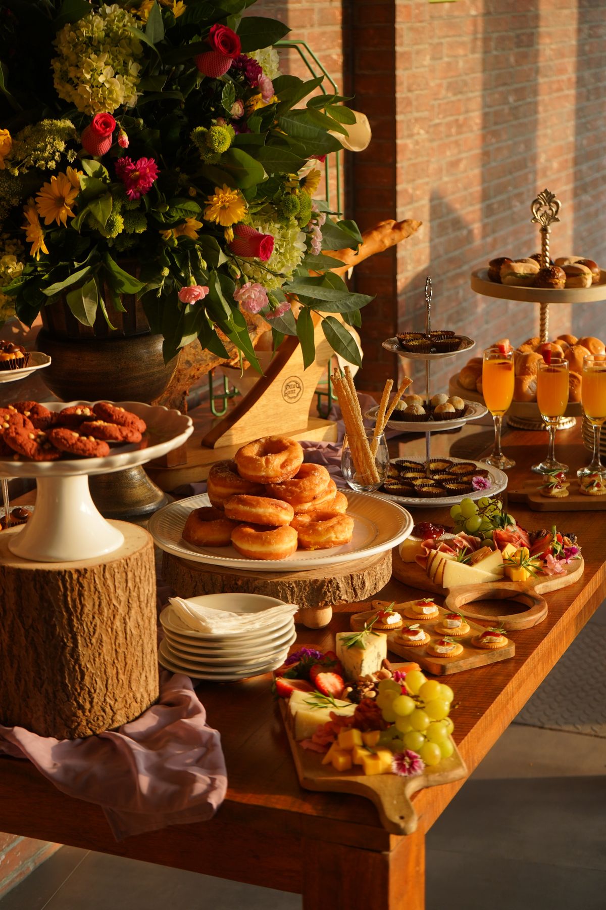 Elegant brunch buffet spread with pastries, mimosas, and fresh flowers