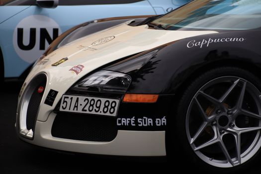 Detailed view of a luxury sports car front displaying custom decals and license plate.