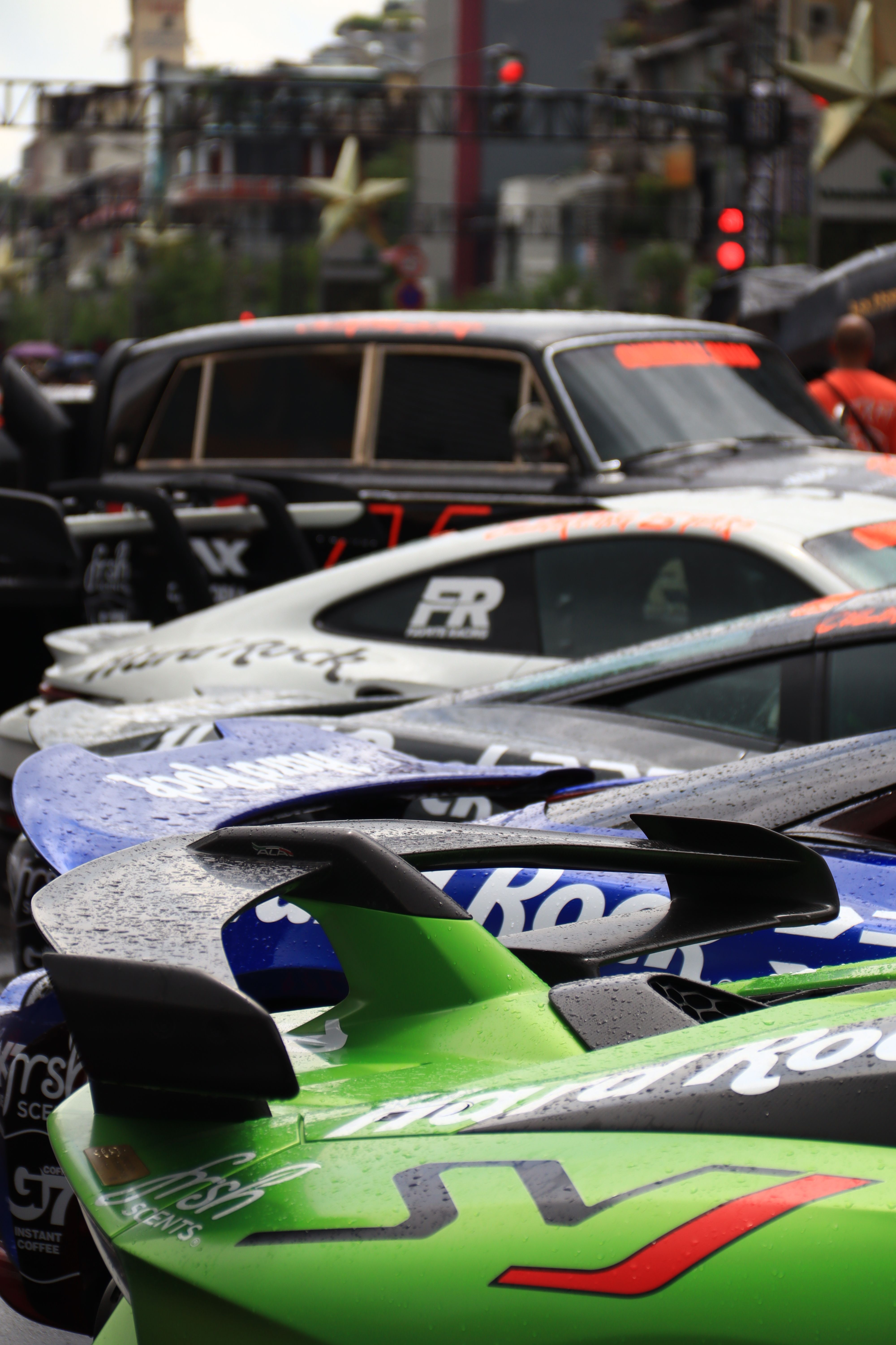 Detailed view of sports cars on a rainy day in a city street.