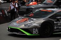 A high-performance sports car showcased in an outdoor automotive event with branding and decals.