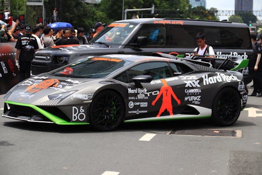 Sleek Lamborghini sports car with custom wrap at a vibrant outdoor gathering.