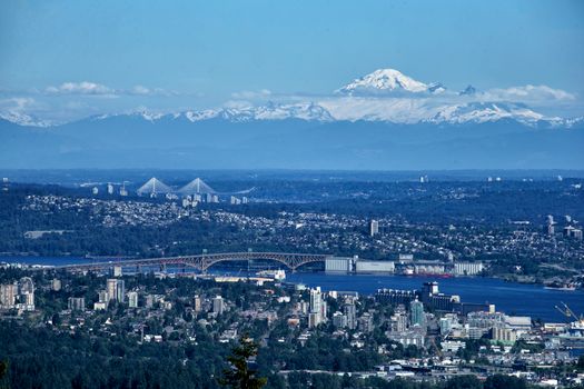 Stunning panoramic view of Vancouver skyline with distant snowy mountains in the background.