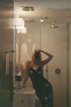 Artistic shot of a woman posing in a stylish New York bathroom mirror reflection.