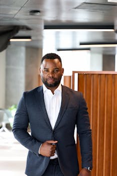 Confident businessman in a suit standing in a modern office building in Copenhagen.