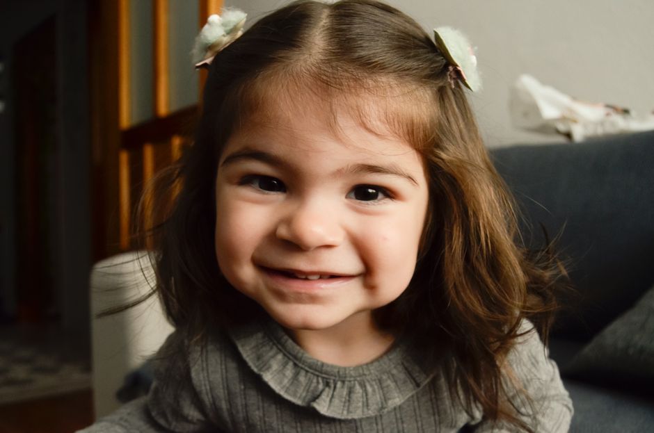 Imagen en primer plano de un niño sonriendo en interiores con luz suave.