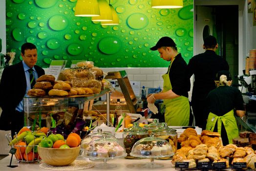 A vibrant cafe in Dublin showcasing a variety of fresh bakery items and fruits, creating a lively atmosphere.