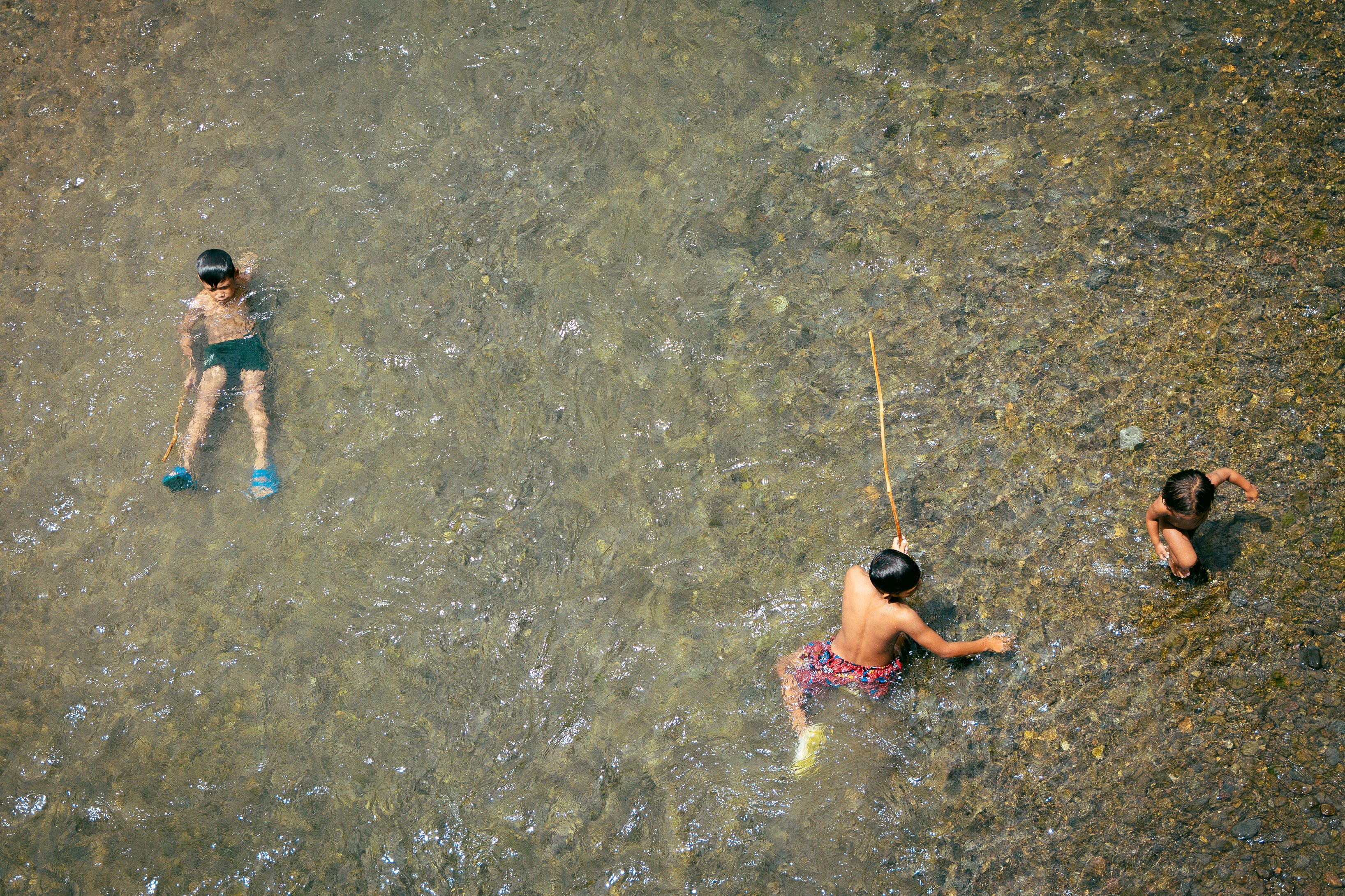 Niños Jugando Alegremente En Un Río Cristalino · Foto de stock gratuita